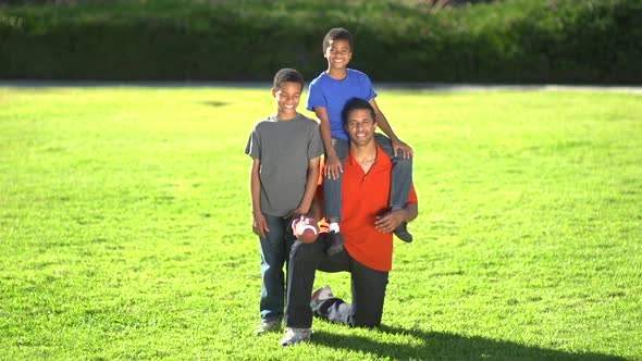 Group portrait of a father and his sons with a football. alt