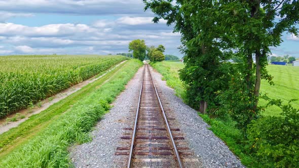 View From the Back of a Train as it Travels along Multiple Tracks Thru Countryside alt