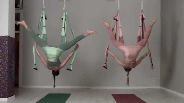 Two Aerial Yoga Teacher During a Class Making Aerial Yoga Elements