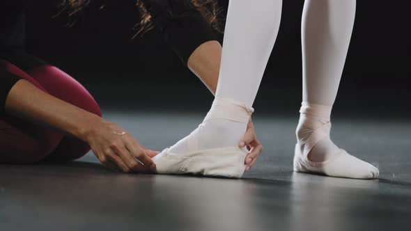Unrecognizable Woman Coach Teacher Teaches Helping Girl Ballerina to Stand on Pointe Shoes Do alt
