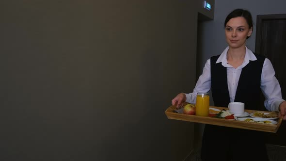 Woman Hotel Worker is Carrying a Breakfast Tray to the Guest's Room