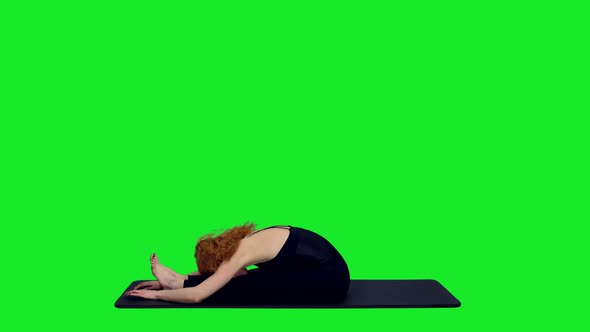 Beautiful Athletic Female Practicing Yoga on Mat Against Green Screen