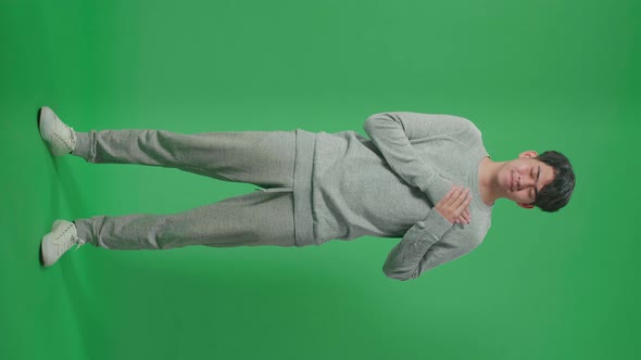 Full Body Of Proud Asian Man Touching Her Chest While Standing In Front Of Green Screen Background alt