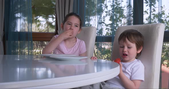 Cute Children Eating Fresh Ripe Strawberries at Home