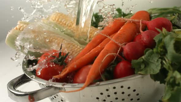 Water splashing onto fresh vegetables, slow motion alt