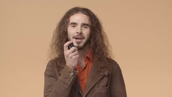 Bearded Messy Guy with Long Hair Making Announcement Using Radio Set Holding Transmitter and alt