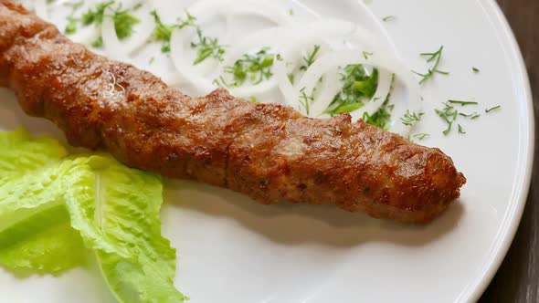 Beef Kebab Rotating on a White Plate