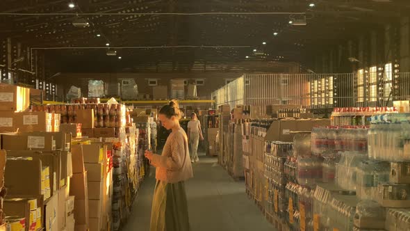 People customers shopping in supermarket wholesale store. Woman walking in shop, choosing goods.