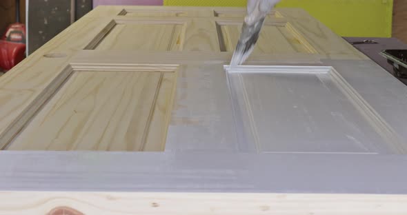 Contractor Painter Updating Colors of Painting Doors Molding Trim Using Hand Roller Painting alt