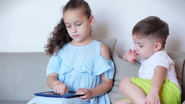 Happy Children Playing at Home Relaxing Use a Smartphone Cuddling Sit on Sofa Daughter and Son,look alt
