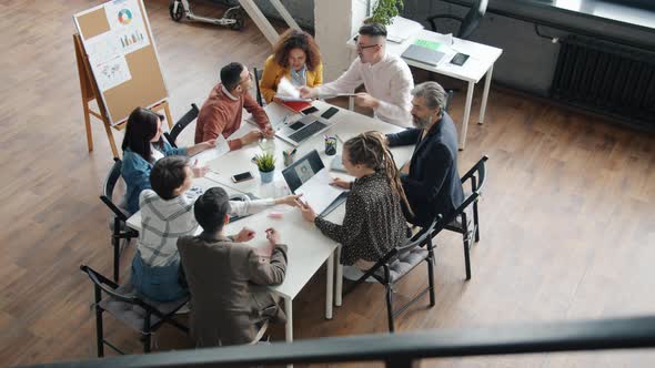 Business Teammates Talking and Exchanging Documents Working at Project in Office alt