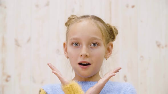 Portrait Surprised Girl with Opened Mouth and Eyes Looking to Camera on Light Background in Studio alt