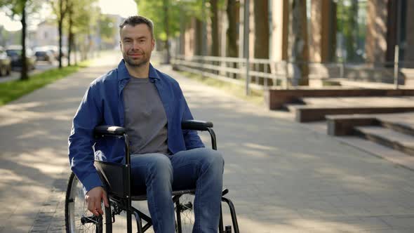 Portrait of the Happy Man on a Wheelchair Wearing Casual Clothes alt