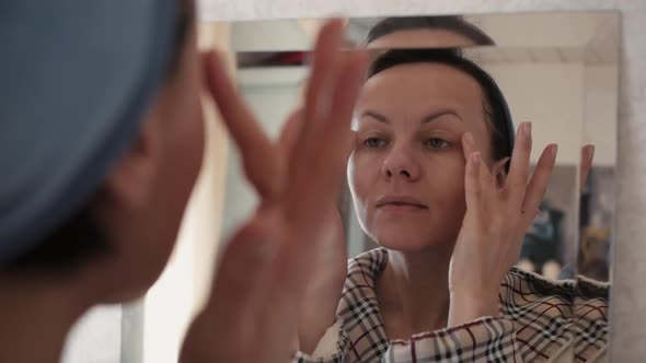 Portrait Of Beautiful Healthy Woman Putting Moisturizing Cream On Face.