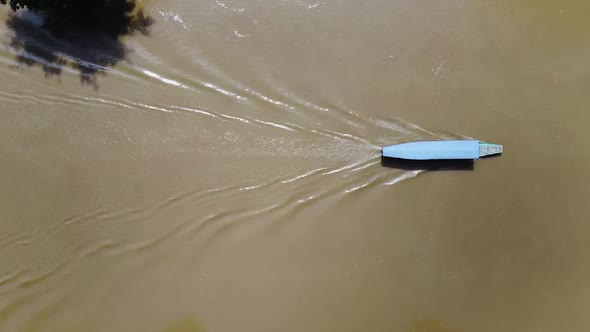 A Tourist Boat Sails Along the River Between Mountains and Green Forests in Asia Around the Jungle alt