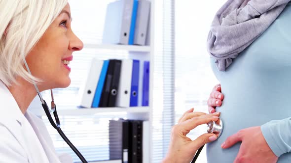 Pregnant woman consulting a female doctor alt