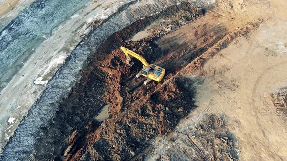 Top View of a Digging Vehicle Working in the Borrow Pit Building, Construction Process. alt