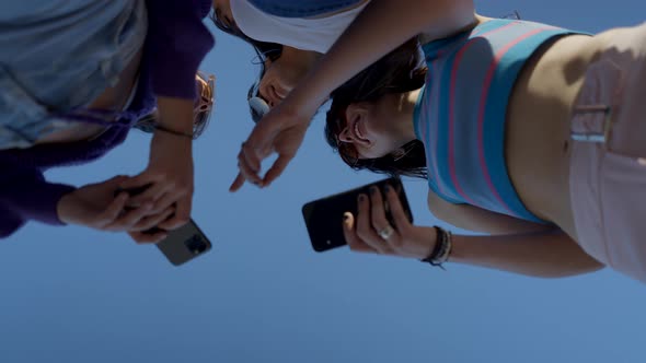 Happy Girls in Sunglasses Use Phones and Talk Close View From Below alt