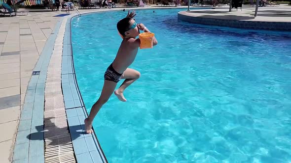 A Boy Jumps Into the Pool
