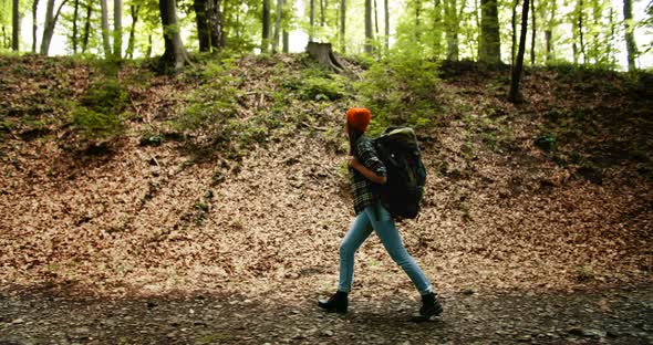 Sideview of Woman with Backpack in Forest