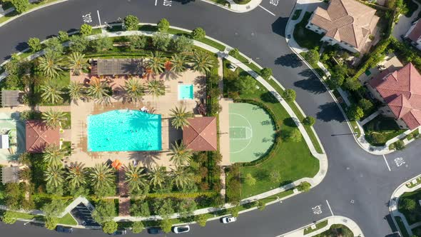 Aerial overhead shot of tropical Orchard Vista Park with palm trees and swimming pool during sunny d alt