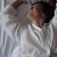 a Brunette Woman Lies on a White Sheet and Throws Up a Pillow - VideoHive Item for Sale