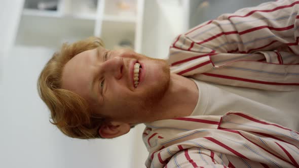 Guy Laughing Webcam Call at Home Interior Closeup alt