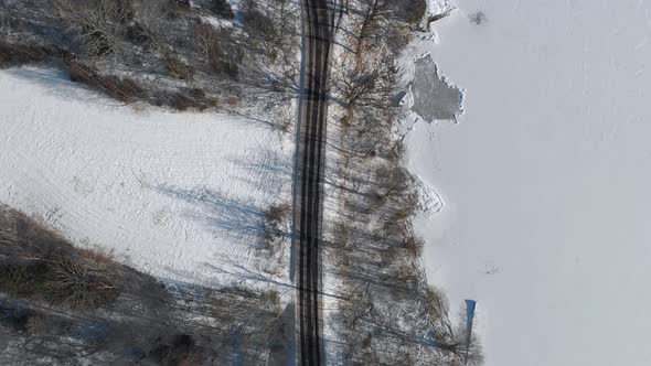 Road Along Shoreline Frozen Lake with Snow Aerial Top Down alt