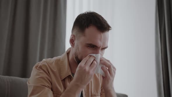 Runny Nose in a Man Holding Tissue Handkerchief Blowing Wiping His Running Nose alt