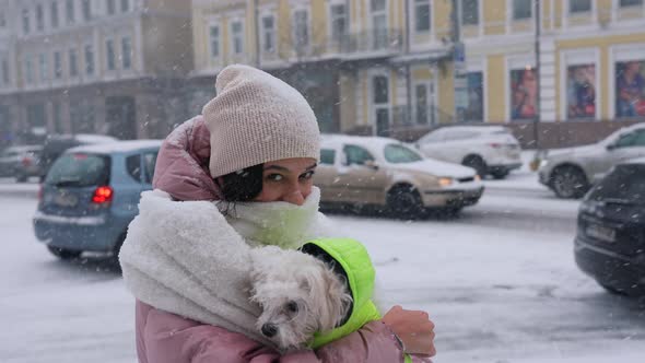 Girl with a Dog in Her Arms Snow is Falling