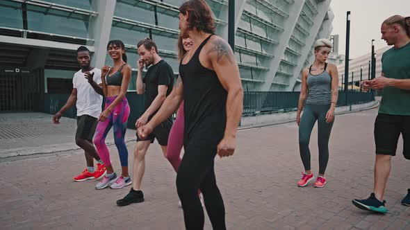 Group of Likeminded Multiracial Friends Walk Together After Completing a Workout alt