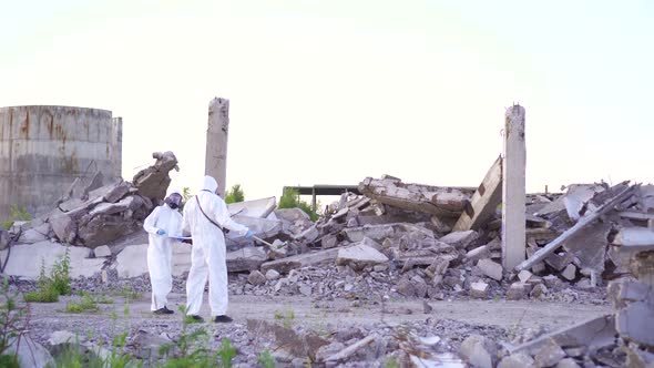 Scientists in Protective Suits and Masks and Apersonal Ionizing Radiation Dosimeter Walk Measure alt