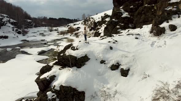 Video From the Height of a Lonely Girl Stands on Top of a Snowcovered Mountain