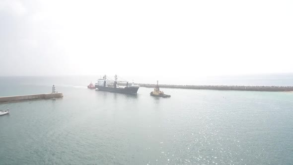 Cargo ship being towed alt