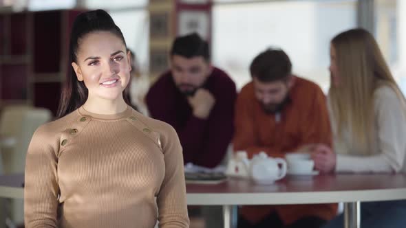 Portrait of Pretty Brunette Caucasian Woman with Brown Eyes Looking at Camera and Smiling. Positive alt
