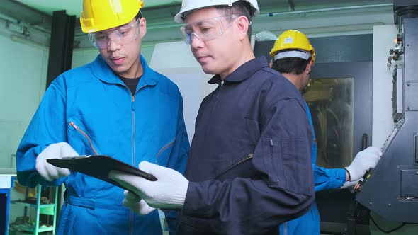 Professional engineering walking discuss inspecting with engineer team machinery factory area. alt