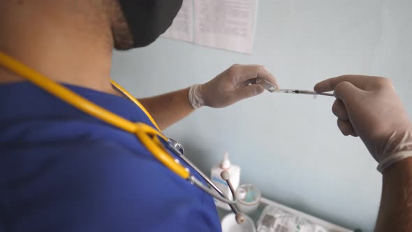 Unrecognizable Doctor Wearing Medical Gloves Filling Syringe with Covid19 Vaccine alt