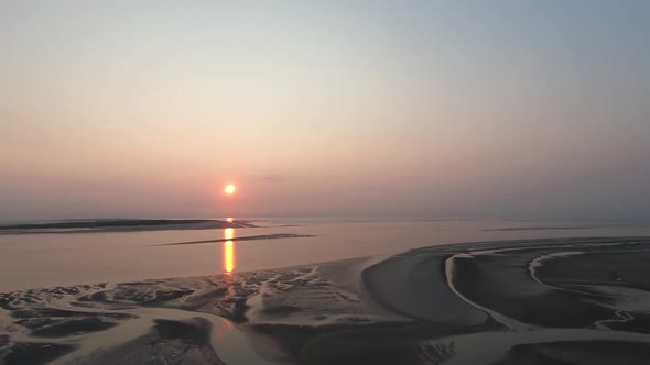 Aerial view overlooking cool patterns on a beach, towards sunset, on Langeoog island alt
