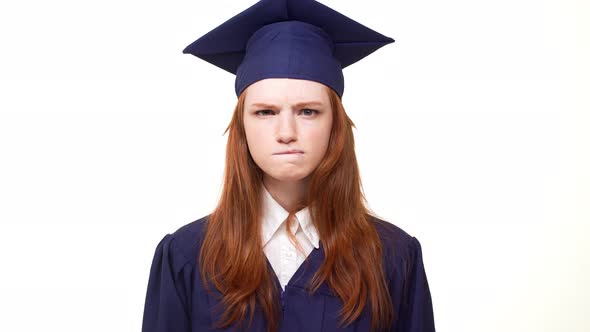 Nervous Ginger Caucasian Graduate Girl Standing on White Background in Blue Academical Dress with alt