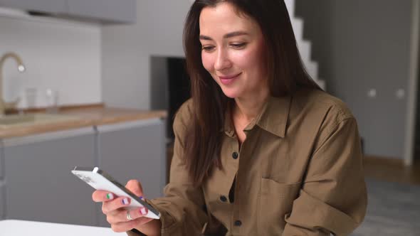 Cheerful Young Asian Woman Using Smartphone Shopping App for Buying Online