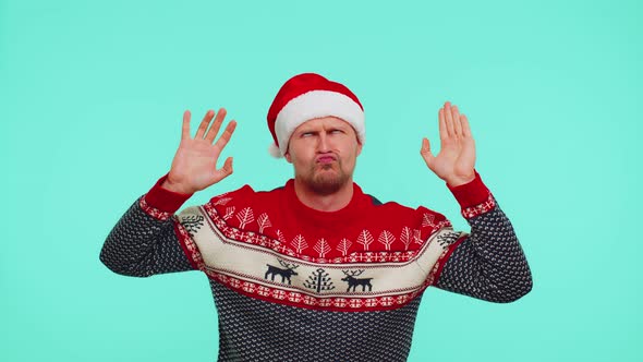 Crazy Man in Sweater Santa Christmas Hat Demonstrating Tongue Out Fooling Around Making Silly Faces alt