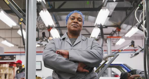 African American female car mechanic crossing her arms and looking at camera alt