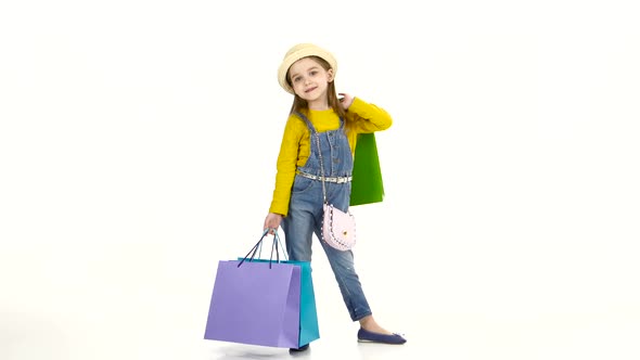 Little Girl Spinning Around Itself with Colorful Packages. White Background alt