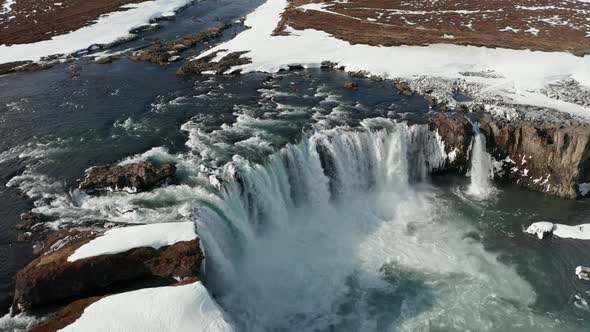 Aerial View of Godafoss Waterfall with Snowy Shore and Ice, Iceland, Winter 2019