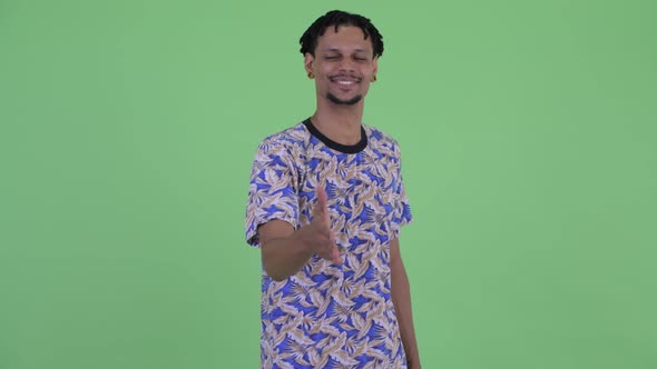 Happy Young Handsome African Man Giving Handshake alt
