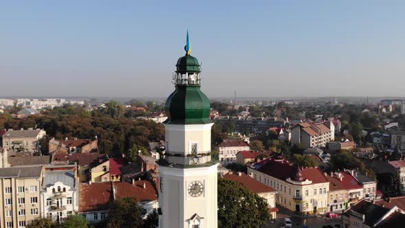 Aerial pan around tower of Drohobych town hall, Scenic cityscape. Sunny morning alt