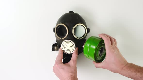 Male hands check green filter on gas mask on white background. Close up.