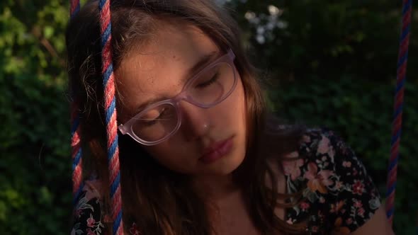 Young Teen Girl Is Sleepy On Swing