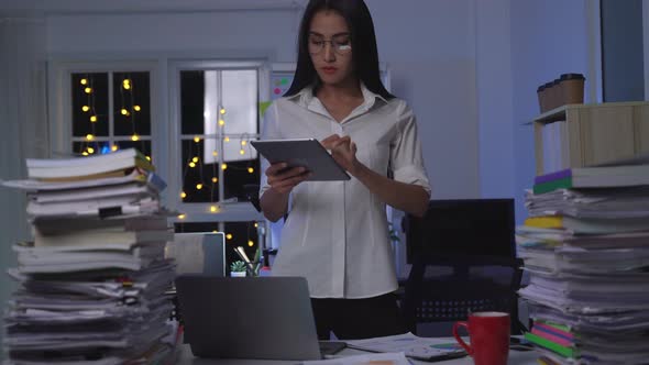 Asian woman work late at night in office while coronavirus pandemic