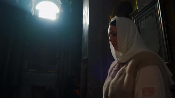 a Woman Stands in the Church and Prays alt
